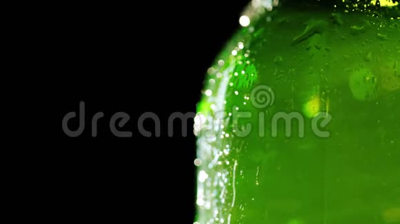 一瓶冷啤酒的一部分凝结水滴在玻璃上流动在黑色的背景下自由的空间视频的预览图