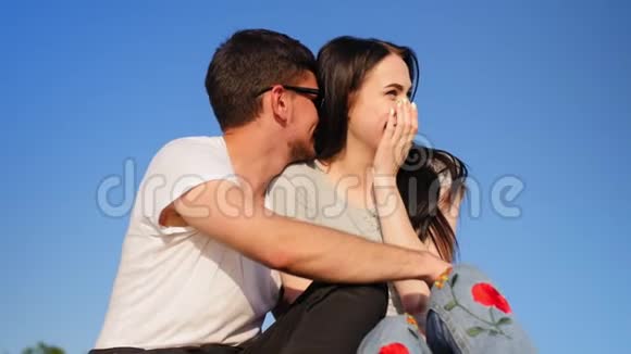 浪漫的幸福夫妇坐在绿色的草地上对抗天空夫妻信任爱和幸福的概念中弹视频的预览图