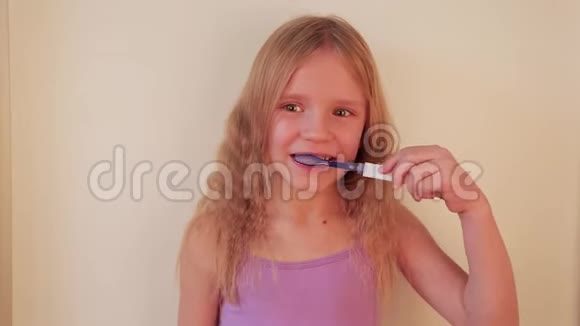 年轻漂亮的金发女孩刷牙健康的观念视频的预览图