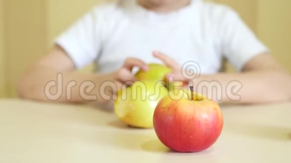 一个孩子在桌子上玩苹果特写镜头镜头的焦点对准苹果视频的预览图