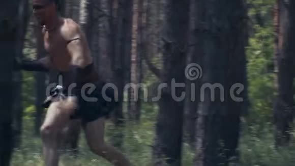 一个穿皮衣服的野蛮人在森林里奔跑的慢镜头视频的预览图