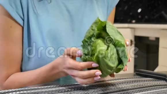 在厨房里用绿色的卷心菜把雌性的手收起来均衡饮食观念节食素食视频的预览图