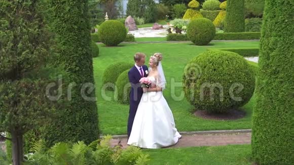 一对新婚夫妇在美丽花园里的画像视频的预览图