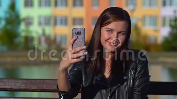 街上漂亮的女孩在你的智能手机上自拍视频的预览图