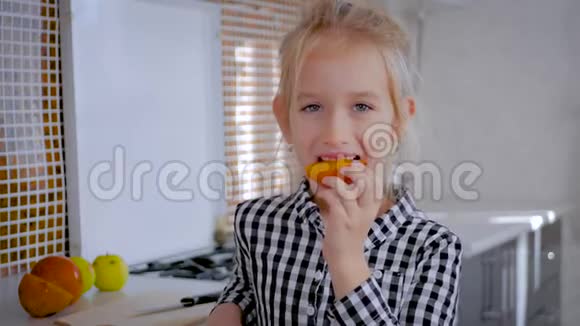 快乐可爱的女孩带水果在厨房孩子们健康的饮食观念健康饮食厨房里的孩子视频的预览图