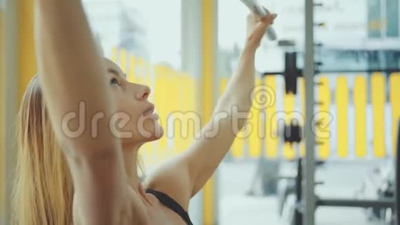 有魅力的年轻白种人女孩在运动中穿着与健身器材在职业健身房锻炼视频的预览图