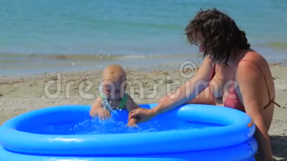 一个女人正在充气游泳池里和一个孩子玩耍视频的预览图