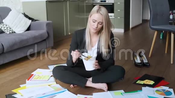 年轻的白种人商业女性工作和吃亚洲食物视频的预览图