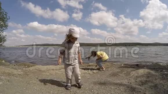 男孩收集石头扔进水里慢动作视频的预览图