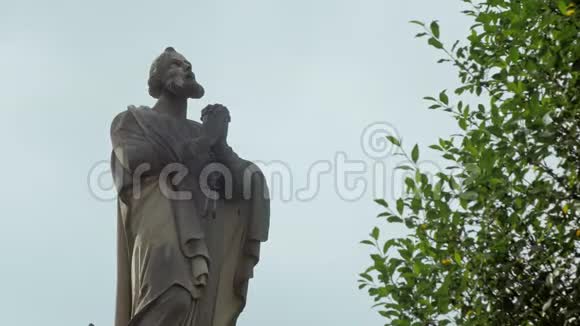 古老的祈祷圣徒雕像仰望天堂双手交叉在胸前特写在户外视频的预览图