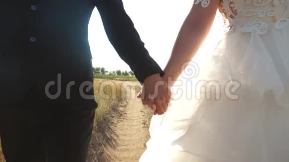 两个幸福的恋人牵着手走在路上特写爱和忠诚的家庭观念视频的预览图