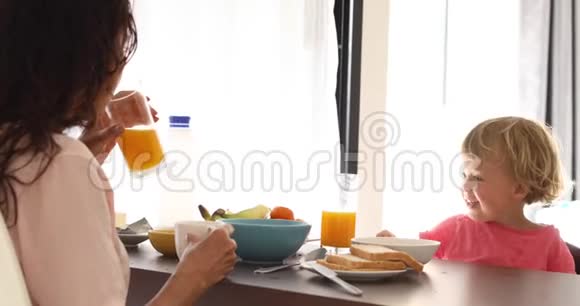 妈妈带着孩子在厨房吃早餐视频的预览图