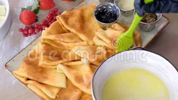 烹饪润滑油与油传统俄罗斯煎饼布里尼双手戴橡胶手套特写带着果酱酸味视频的预览图