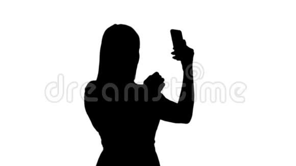 剪影金发女人在智能手机前做准备视频的预览图