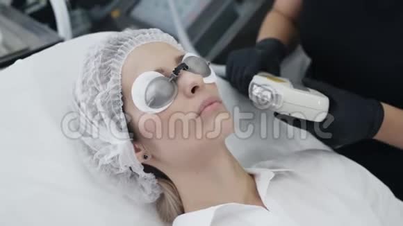 慢动作美容师用特殊器械制作女孩面部皮肤愈合手术视频的预览图
