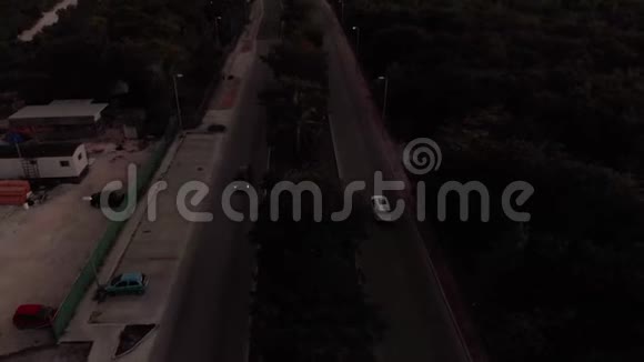 日落时分在墨西哥坎昆附近的一条林荫大道上的空中拍摄这条林荫大道向城市倾斜视频的预览图
