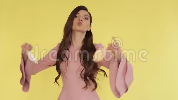美丽的黑发女孩穿着粉红色的连衣裙在五彩纸屑下和糖果跳舞视频的预览图