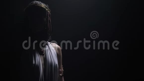 克利奥帕特拉穿着白色连衣裙戴着皇冠站在低灯光下视频的预览图