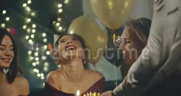 生日快乐女孩在蛋糕上吹蜡烛家庭聚会生日派对家庭友谊生活方式广告视频的预览图