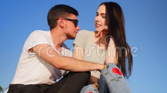 浪漫的幸福夫妇坐在绿色的草地上对抗天空夫妻信任爱和幸福的理念中弹视频的预览图