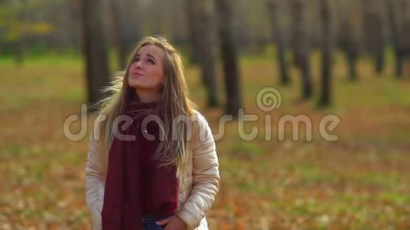 秋天公园里年轻迷人的女孩风从你的头发里掠过视频的预览图