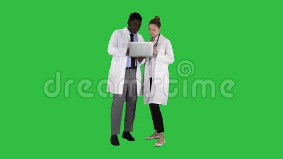 医务人员在灰色笔记本电脑前工作同时站在绿色屏幕上Chroma键视频的预览图