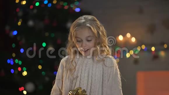 女孩拥抱扭曲的礼盒期待已久的圣诞礼物梦想成真视频的预览图