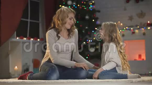 美丽的女士亲吻拥抱女儿等待圣诞前夜的庆祝活动视频的预览图