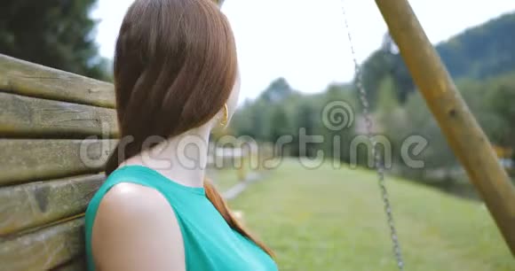 年轻女孩坐在秋千凳上休息视频的预览图