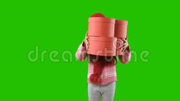 一个扎着辫子的小女孩戴着一顶红色针织帽子和围巾手里拿着两个盒子形状像心脏遮住了脸视频的预览图