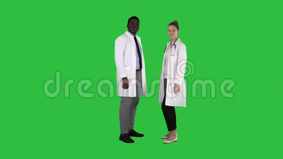 两位白种人和美国黑人微笑医生站在绿色屏幕上ChromaKey的镜头里视频的预览图