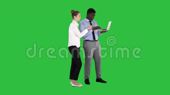 美国黑人商业顾问在笔记本电脑屏幕上显示一些东西在绿色屏幕上与白人女商人交谈视频的预览图