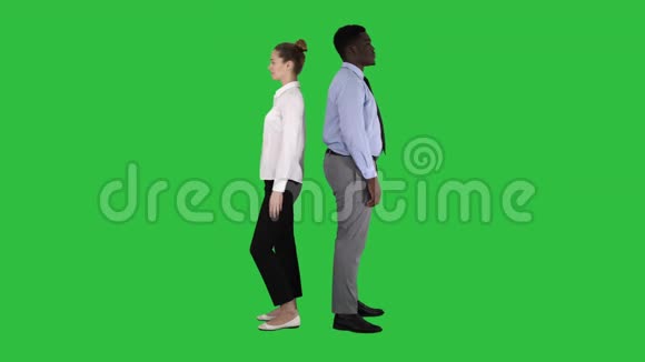 漂亮英俊的男人背靠背站着在绿色屏幕上变换姿势Chroma键视频的预览图