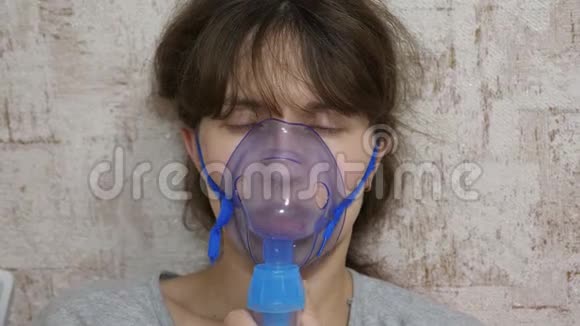 在一家医院里妇女脸上戴着吸入面罩坐在沙发上的喷雾器吸入了生病的女孩视频的预览图