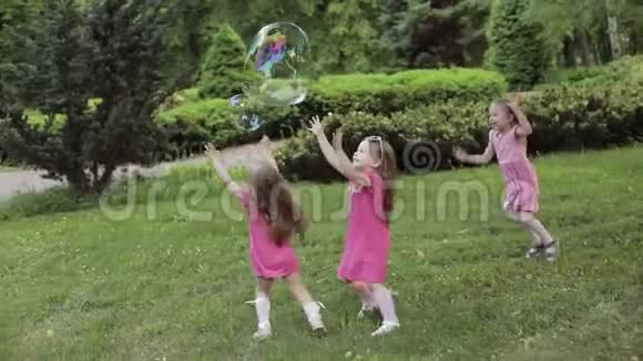 快乐的小女孩在花园里玩泡泡视频的预览图
