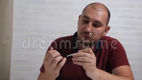 一个可敬的秃头用一种特殊的药物治疗他的指甲以治愈真菌家中手部真菌治疗视频的预览图