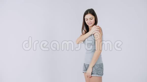 年轻女子肩膀疼痛关节疼痛白色背景孤立视频的预览图