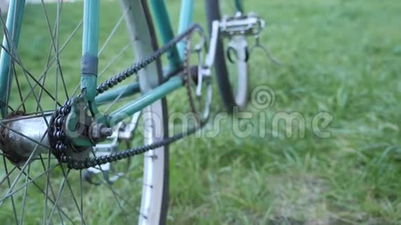 一辆绿色轨道固定复古自行车在绿草上的近景视频的预览图