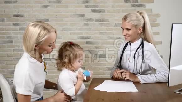 年轻的儿科医生和一个漂亮的小女孩和她的妈妈在医疗诊所交朋友友好医疗视频的预览图