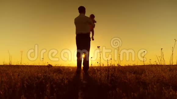 父亲在夕阳下和幼儿跳舞快乐的女儿在公园里和爸爸在秋天公园里晒太阳视频的预览图