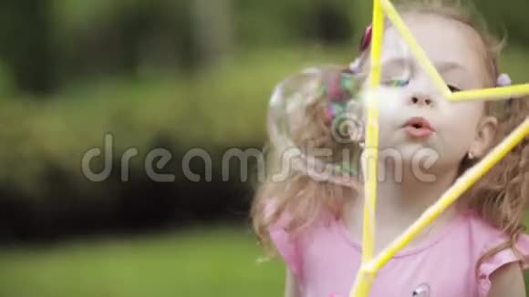 可爱的小孩在公园里吹泡泡视频的预览图