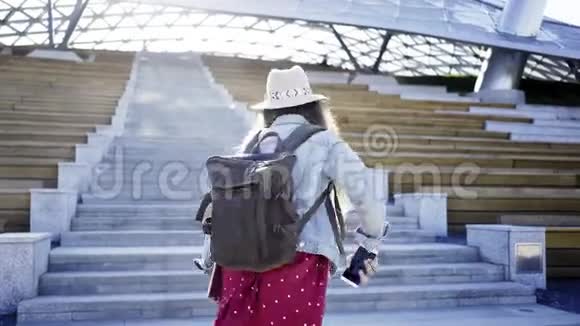 阳光下背包的时髦女人视频的预览图