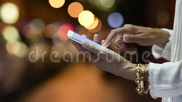 女人晚上用智能手机视频的预览图