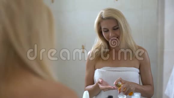 女性在浴室干头发上喷洒再生疗法美容护理视频的预览图