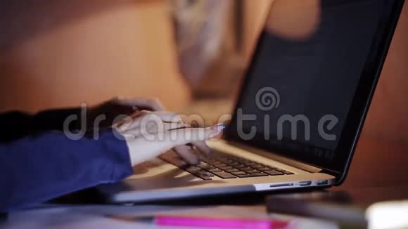 晚上女性用手在笔记本电脑上打字视频的预览图