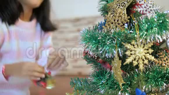 亚洲小女孩装饰圣诞树祈祷最美好幸福亚洲小女孩用h装饰圣诞树视频的预览图