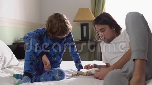 两个哥哥躺在床上哥哥给弟弟读一本书兄弟关系视频的预览图