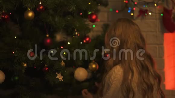 情绪化的小女孩在圣诞树下找礼物庆祝节日视频的预览图