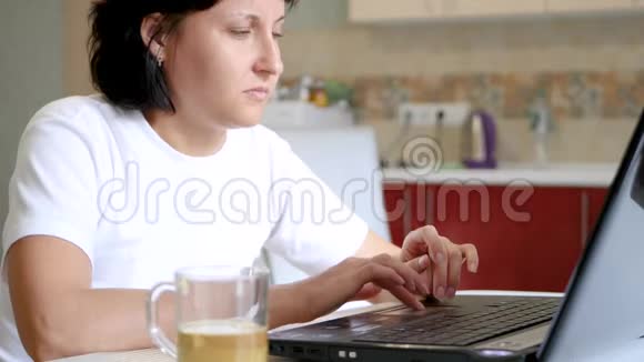 博主女孩正坐在桌旁用笔记本电脑桌上有一杯茶视频的预览图