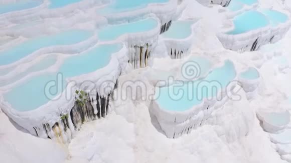 在土耳其帕穆卡莱镜头从石灰华向游客倾斜空中录像视频的预览图
